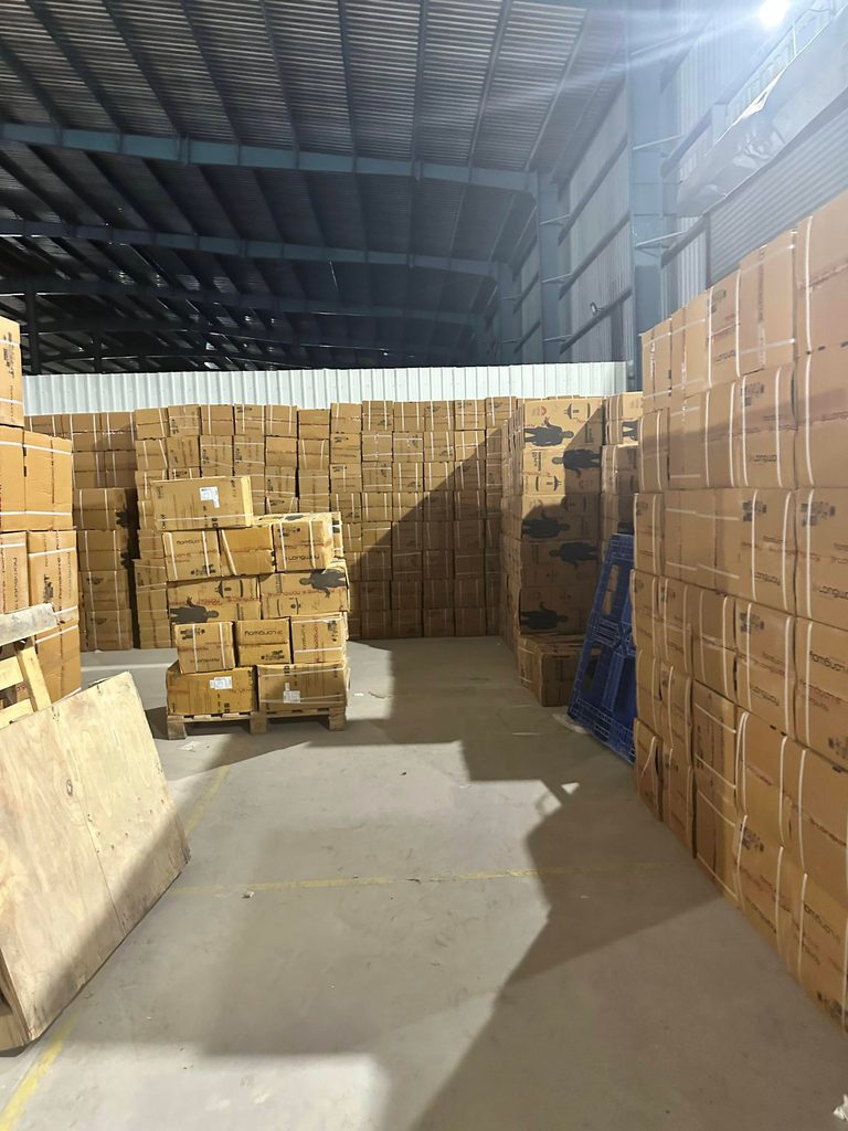 View of electronics and appliance warehouse with RFID testing setup and floor stacks